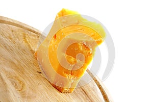 Solid gauda cheese on wood