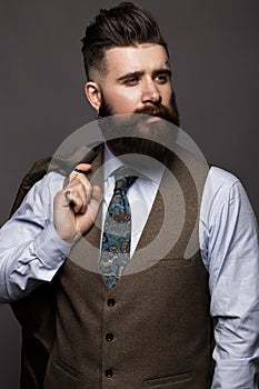 Solid man with beard and mustache in classic fashionable suit.