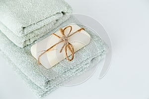 Solid soap corded on bath towels on white background with copy space.