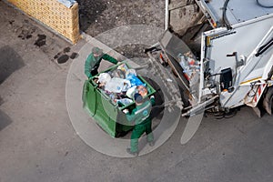 Solid waste collection workers loading garbage truck
