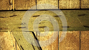 A solid wooden background made of old vertical and one horizontal boards and one angled, connected by nails