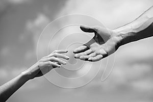 Solidarity, compassion, and charity, rescue. Hands of man and woman reaching to each other, support. Giving a helping