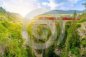 Solis Viaduct of Swiss railway with red train photo