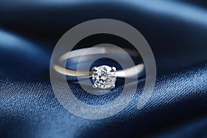 Solitaire diamond engagement ring on satin