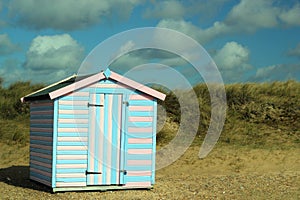 Solitary beach hut in the sand dunes.