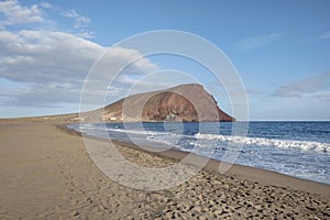 Solitary coastal landscape featuring a large empty beach known locally as Playa de la Tejita and the volcanic cone, Montana Roja photo