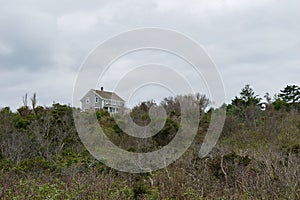 Solitary house standing at the top ridge of a green autumnal hill side, Block Island, RI