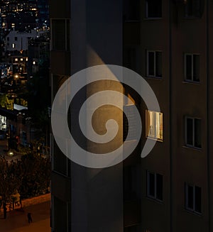 Solitary Lit Window Illuminates Fire Escape in Nighttime Apartment Scene