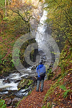 Solitary man looking up at Grey Mare`s Waterfall in Kinlochleven, Scottish Highlands