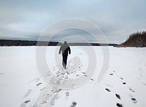 Solitary man on snowy frozen river