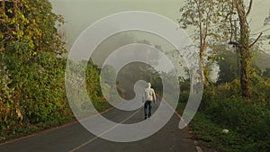 Solitary man walking down winding road