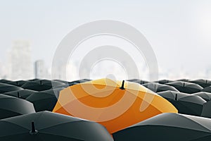 Solitary orange umbrella amidst black ones against blurred cityscape. Uniqueness and individuality concept.