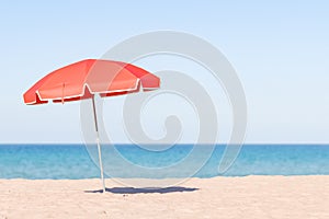 Solitary Red Beach Umbrella on Sandy Shore with Ocean Horizon