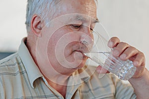 Solitary Savor Elderly Man Relishing a Glass of Water in the Comfort of Home