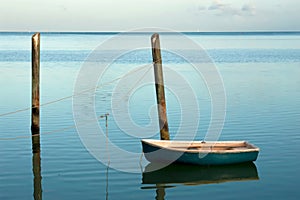 Solitary small boat moored at sunrise.