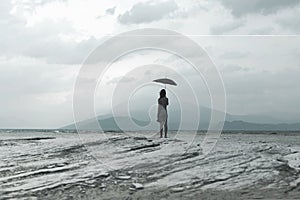 Solitary woman looks at infinity and uncontaminated nature on a stormy day