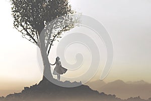 Solitary woman under a tree looking at a mystical and suggestive landscape