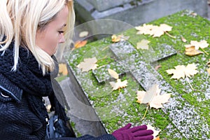 Solitary woman visiting relatives grave.