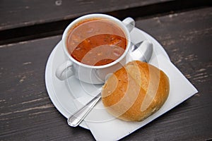 Soljanka with bread roll and spoon