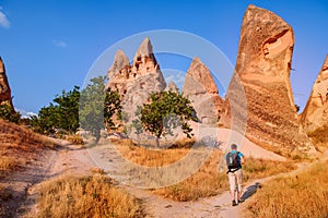 Solo backpacker hiking among the cave rocks