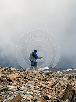 Solo climbing. Activities man climb to the top of a misty stone hill.  People in difficult conditions. Difficult climb to the top