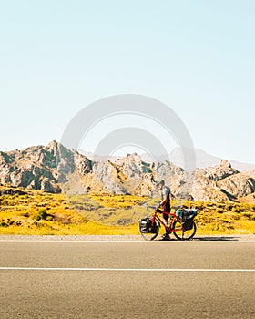 Solo cyclist on road with bicycle check map being lost outdoors in hot sunny day in deserted wilderness. Sportsman cyclist check