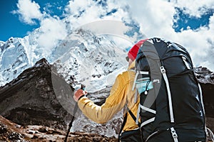 Solo hiker exploring high altitude sunny mountains. Outdoor tourist wearing mountain equipment walking across huge massive rocky