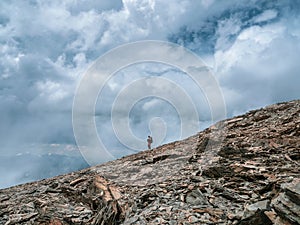 Solo hiking in the mountains. A man climbs a mountain slope.  Adventure solo traveling lifestyle concept, active weekend vacations