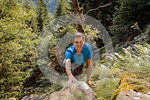 Solo man climbing a rock in the forest