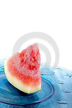 Solo peice of watermelon on blue glass palte