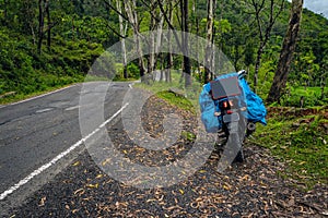 Solo traveler loaded bike with isolated road and amazing background