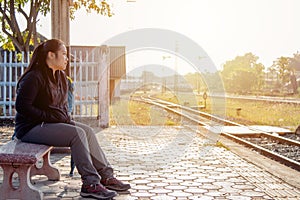 Solo traveller : Asian woman waiting train for journey in train station. Woman backpacking starting traveling on train station