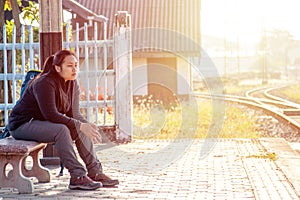 Solo traveller : Asian woman waiting train for journey in train station. Woman backpacking starting traveling on train station