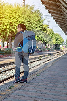 Solo traveller : Asian woman waiting train for journey in train station. Woman backpacking starting traveling on train station