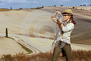 Solo traveller woman taking photos with retro photo camera