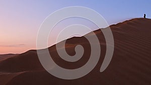 Solo woman stand on top dune enjoy panorama and sunset in Kashan desert