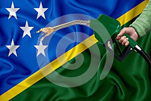SOLOMON ISLANDS flag Close-up shot on waving background texture with Fuel pump nozzle in hand. The concept of design solutions. 3d