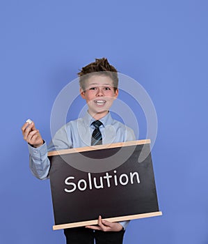 Solution concept. Boy with chalkboard slate on blue background.