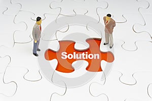 SOLUTION inscription written on jigsaw puzzle and businessman miniature