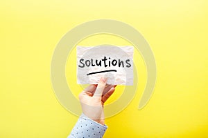 Solutions - card in hand with text about business motivation on yellow background