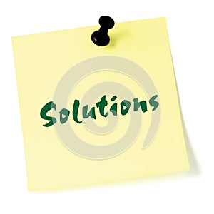 Solutions, written on a sticky adhesive note, isolated yellow post-it style sticker, black thumbtack pushpin, green text