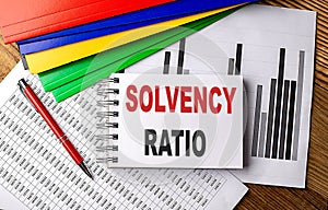 SOLVENCY RATIO text on notebook with pen, folder on a chart background photo