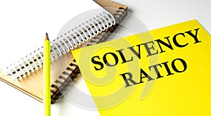 SOLVENCY RATIO text written on yellow paper with notebook