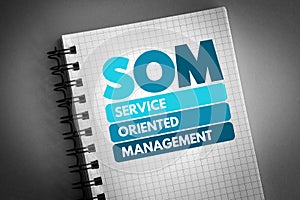 SOM - Service Oriented Management acronym on notepad, business concept background