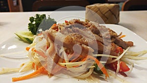 Som Tam or Papaya Salad with Grill Pork and Sticky Rice in Bamboo Container