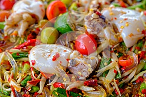Som Tam Seafood Spicy Papaya Salad with salted squid, on woode