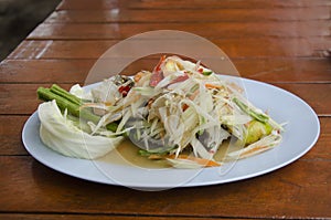 Som Tum or thai food fruit spicy green papaya salad with blue cr