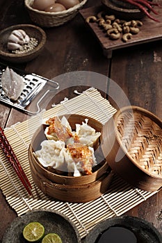 Somay or dimsum. The dim sum is poured with peanut sauce in a steamed bamboo container