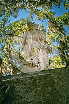 A somber Stature guards the Entrance to the Bonaventure Cemetery historic landmark in Savannah Georgia photo