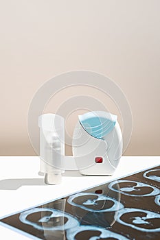 Some asthma inhalers and CT scan of the lungs on white table. Aerosol for inhalation for treat lung inflammation and prevent